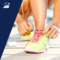 Eine Läuferin bindet einen Laufschuh