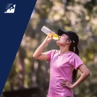 Eine Läuferin trinkt ein Sportgetränk mit Elektrolyten