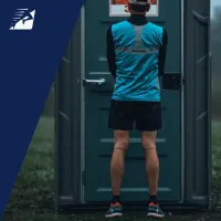 Läufer wartet vor einer Toilette