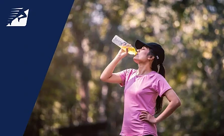 Eine Läuferin trinkt ein Sportgetränk mit Elektrolyten